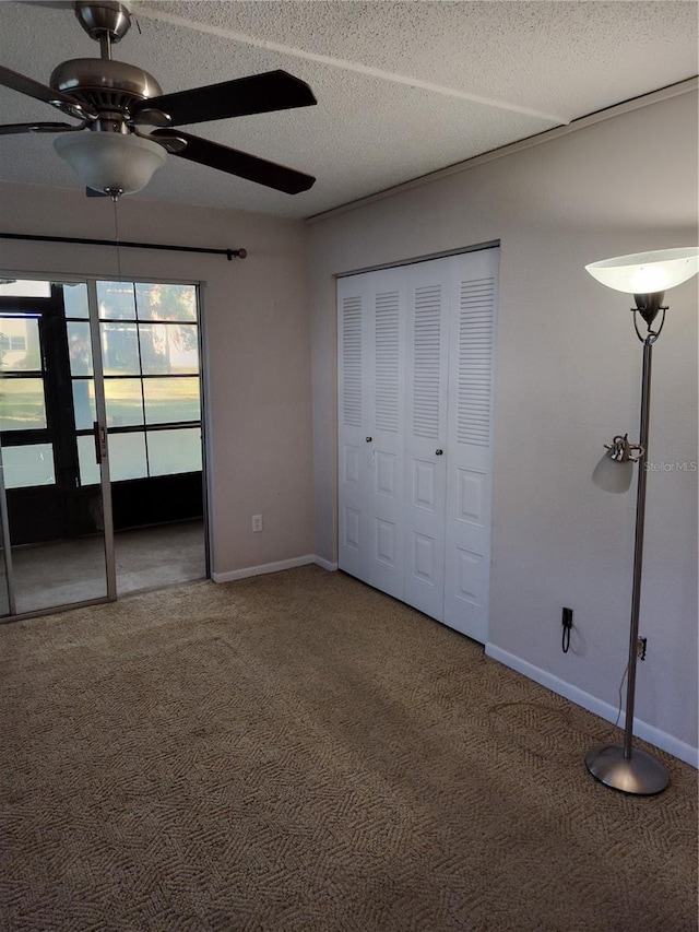 unfurnished bedroom with ceiling fan, a closet, a textured ceiling, and carpet