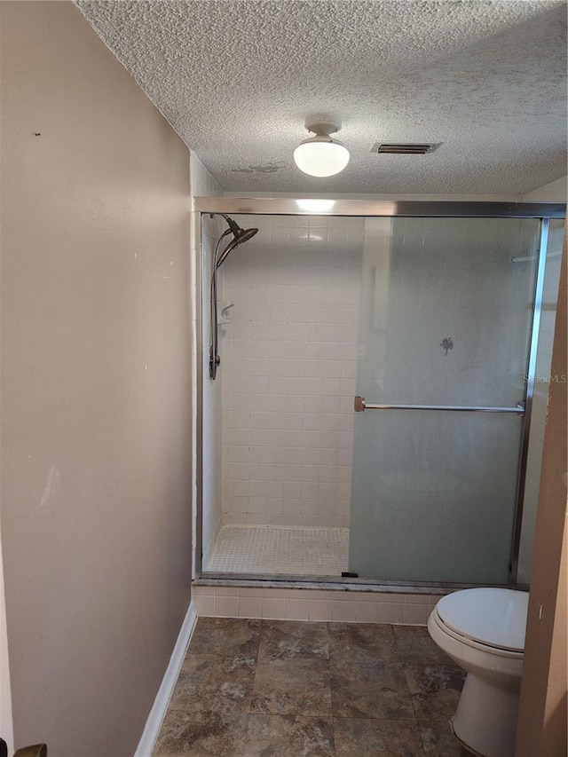 bathroom featuring an enclosed shower, a textured ceiling, and toilet