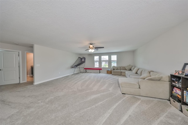 living room featuring ceiling fan, light colored carpet, and a textured ceiling