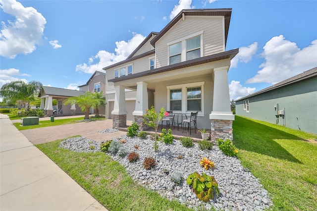 craftsman inspired home featuring a front yard and covered porch