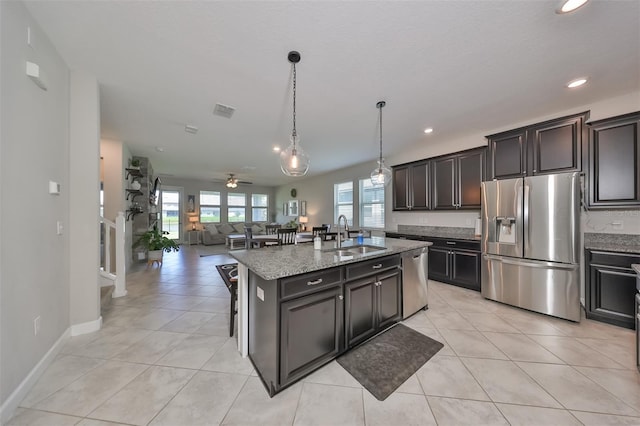 kitchen with sink, a center island with sink, plenty of natural light, pendant lighting, and stainless steel appliances