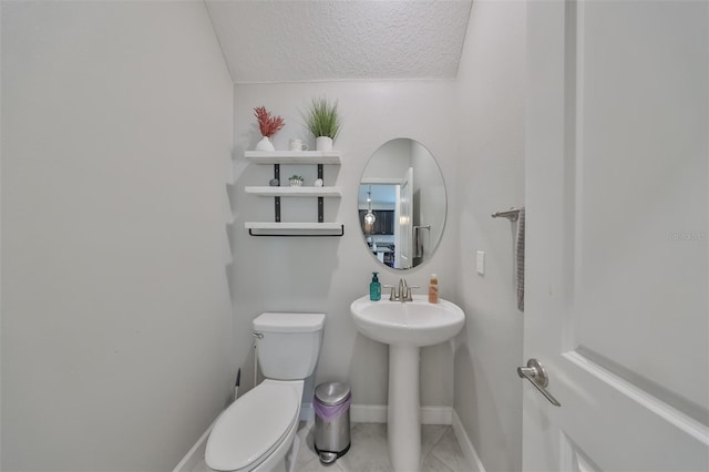 bathroom featuring tile patterned flooring, toilet, and a textured ceiling