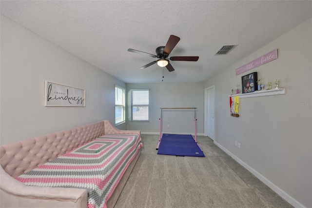 carpeted bedroom featuring ceiling fan and a textured ceiling