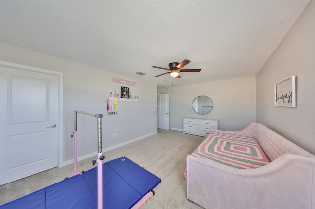 carpeted bedroom with ceiling fan and a textured ceiling