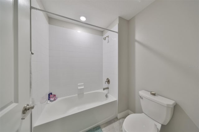 bathroom with tiled shower / bath combo and toilet