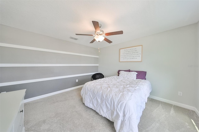 carpeted bedroom with ceiling fan and a textured ceiling