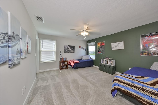 bedroom with light carpet, a textured ceiling, and ceiling fan