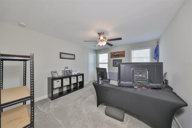 carpeted office space featuring a textured ceiling and ceiling fan