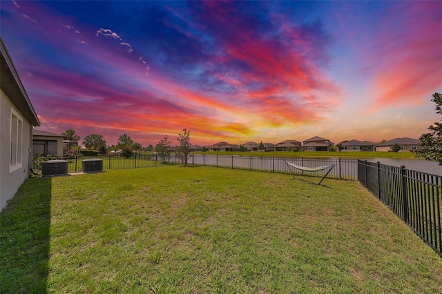 yard at dusk featuring cooling unit