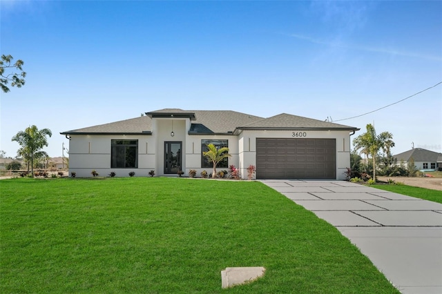 prairie-style home featuring stucco siding, a shingled roof, a garage, driveway, and a front lawn