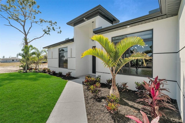 exterior space featuring a lawn and stucco siding