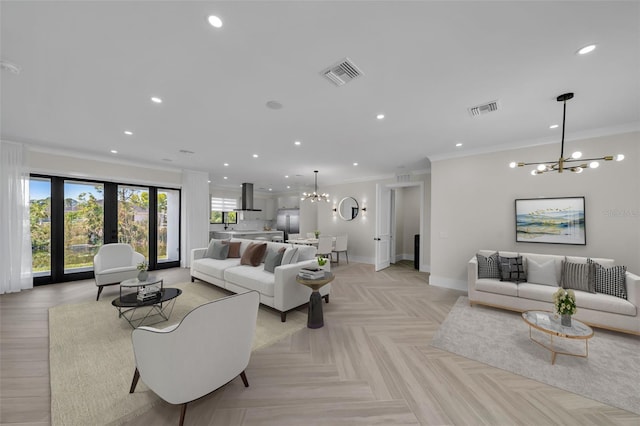 living room with a notable chandelier, ornamental molding, french doors, and light parquet floors