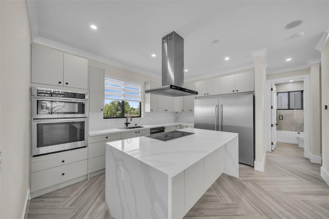 kitchen featuring appliances with stainless steel finishes, light parquet floors, island exhaust hood, a center island, and crown molding