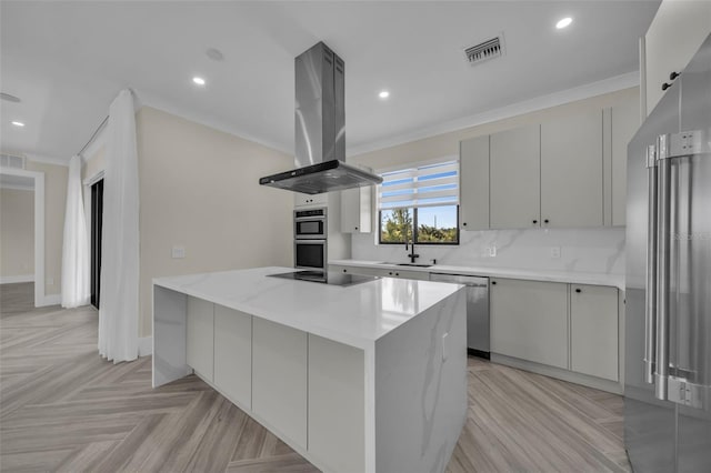 kitchen featuring island range hood, stainless steel appliances, a center island, and light parquet floors