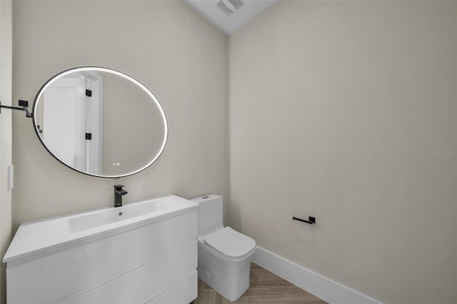 bathroom featuring vanity, toilet, and hardwood / wood-style floors