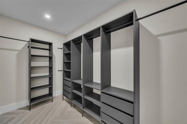 walk in closet with light parquet floors