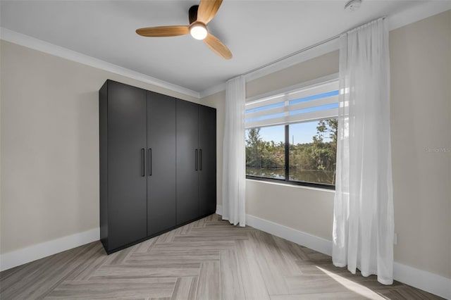 bedroom featuring ceiling fan, ornamental molding, a closet, and light parquet floors