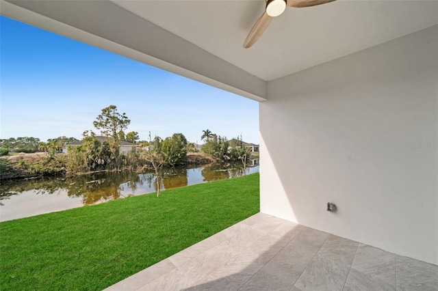 view of yard with a water view, ceiling fan, and a patio area