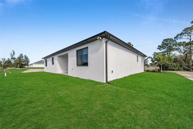 view of side of property with a lawn and stucco siding