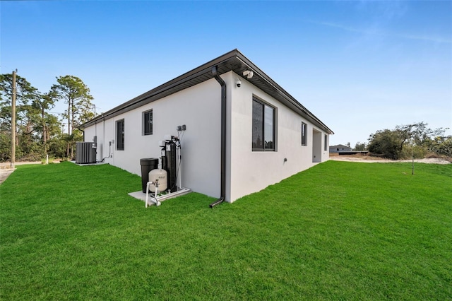 view of home's exterior featuring stucco siding, a lawn, and central air condition unit