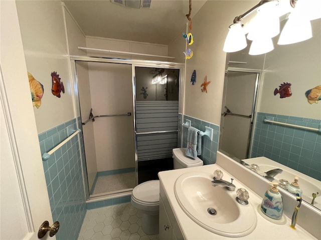 bathroom featuring tile walls, vanity, tile patterned floors, toilet, and walk in shower