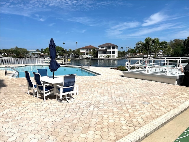 view of pool featuring a patio area and a water view