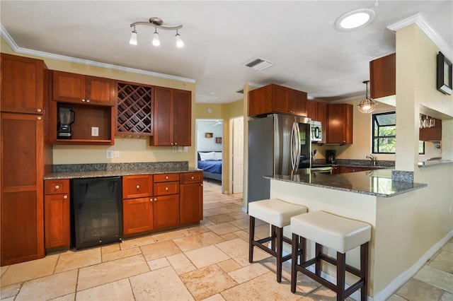 kitchen with hanging light fixtures, a kitchen breakfast bar, stainless steel appliances, beverage cooler, and dark stone counters