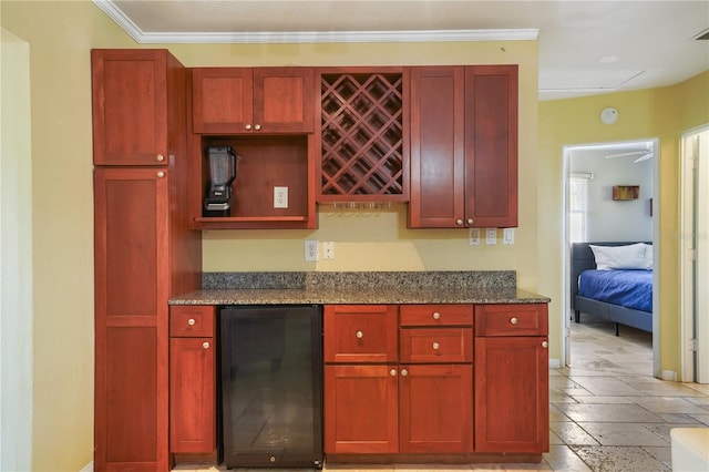 kitchen with ornamental molding, wine cooler, refrigerator, and dark stone counters