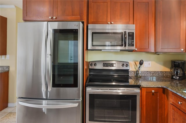 kitchen featuring crown molding, appliances with stainless steel finishes, light stone countertops, and light tile patterned floors