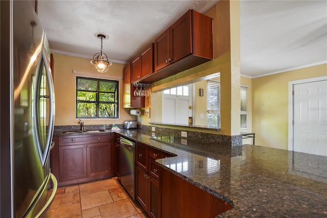 kitchen with ornamental molding, appliances with stainless steel finishes, decorative light fixtures, and dark stone countertops