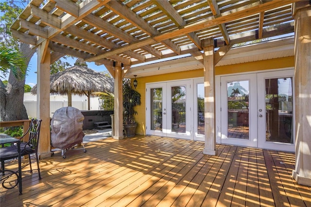 wooden deck featuring a pergola, a hot tub, and french doors