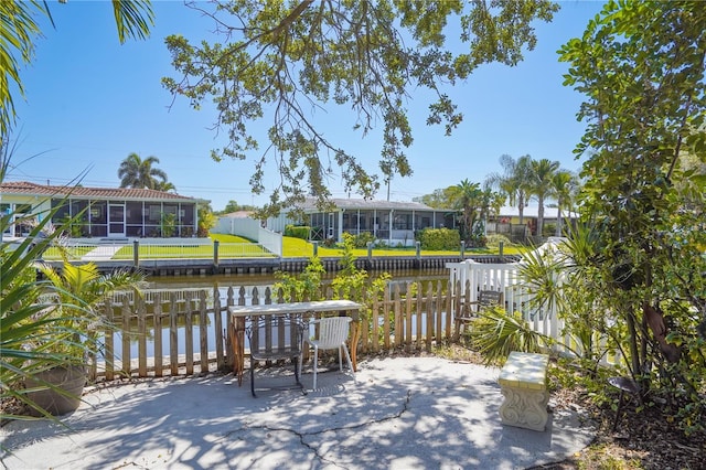 view of patio with a sunroom and a water view