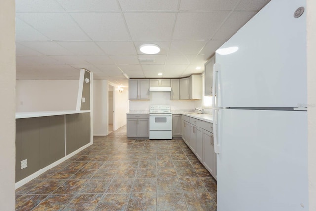 kitchen with gray cabinetry, sink, white appliances, and a paneled ceiling