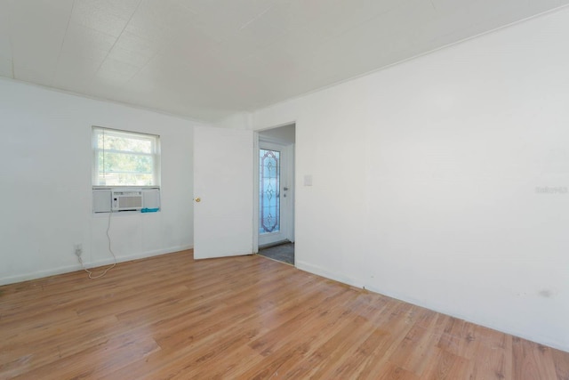 unfurnished room with cooling unit and light hardwood / wood-style floors