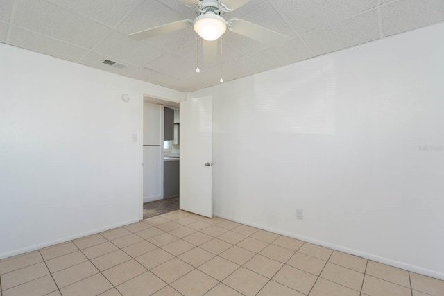 unfurnished room featuring light tile patterned floors, a drop ceiling, and ceiling fan