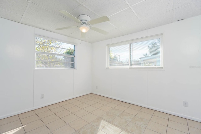 unfurnished room featuring a paneled ceiling, a wealth of natural light, and ceiling fan