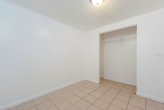 unfurnished bedroom featuring a closet and light tile patterned flooring