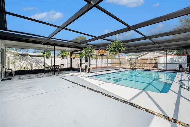 view of swimming pool with glass enclosure and a patio area