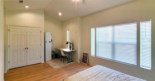 bedroom with visible vents, wood finished floors, vaulted ceiling, a closet, and recessed lighting