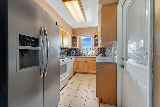 kitchen featuring light brown cabinetry, sink, backsplash, light tile patterned floors, and white appliances