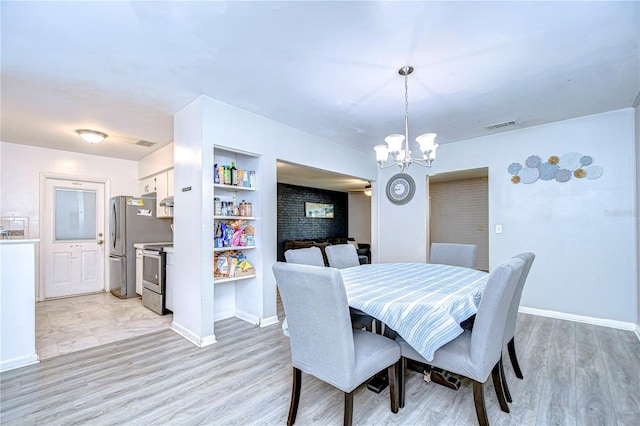 dining space featuring a notable chandelier and light hardwood / wood-style floors