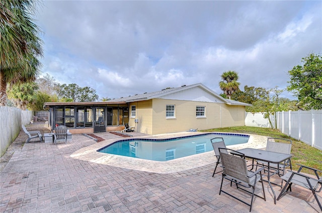 view of swimming pool featuring a patio and a sunroom