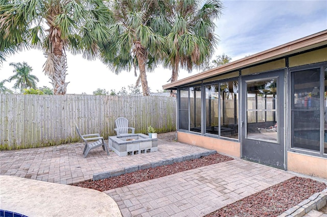 view of patio / terrace with a sunroom and an outdoor fire pit