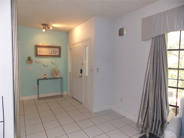 interior space with baseboards and light tile patterned floors