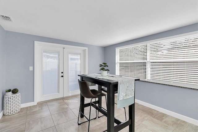 dining area featuring light tile patterned floors and french doors