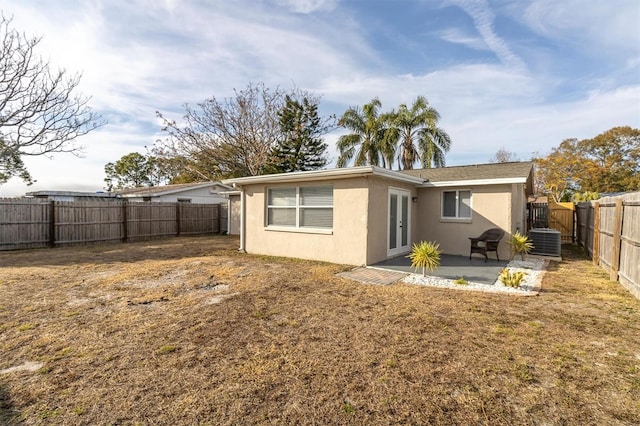 back of house featuring a lawn, central AC, and a patio area