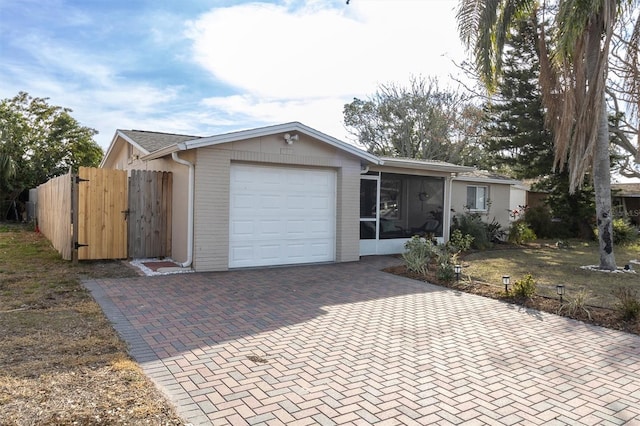 view of front of home with a garage and a sunroom