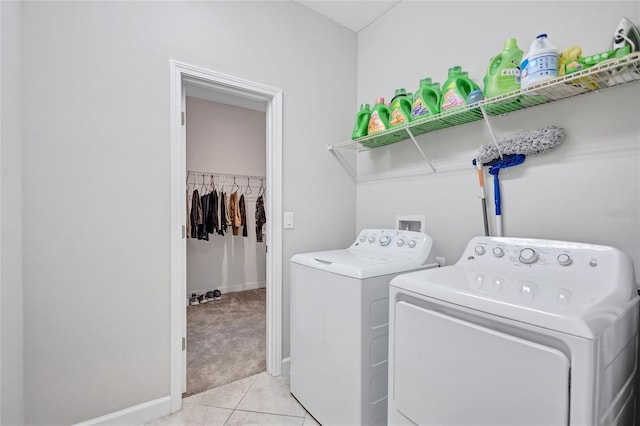 clothes washing area featuring light tile patterned floors and washing machine and clothes dryer