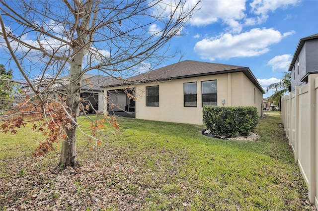 rear view of house featuring a yard