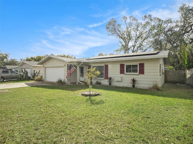 single story home with fence, driveway, a front lawn, and solar panels